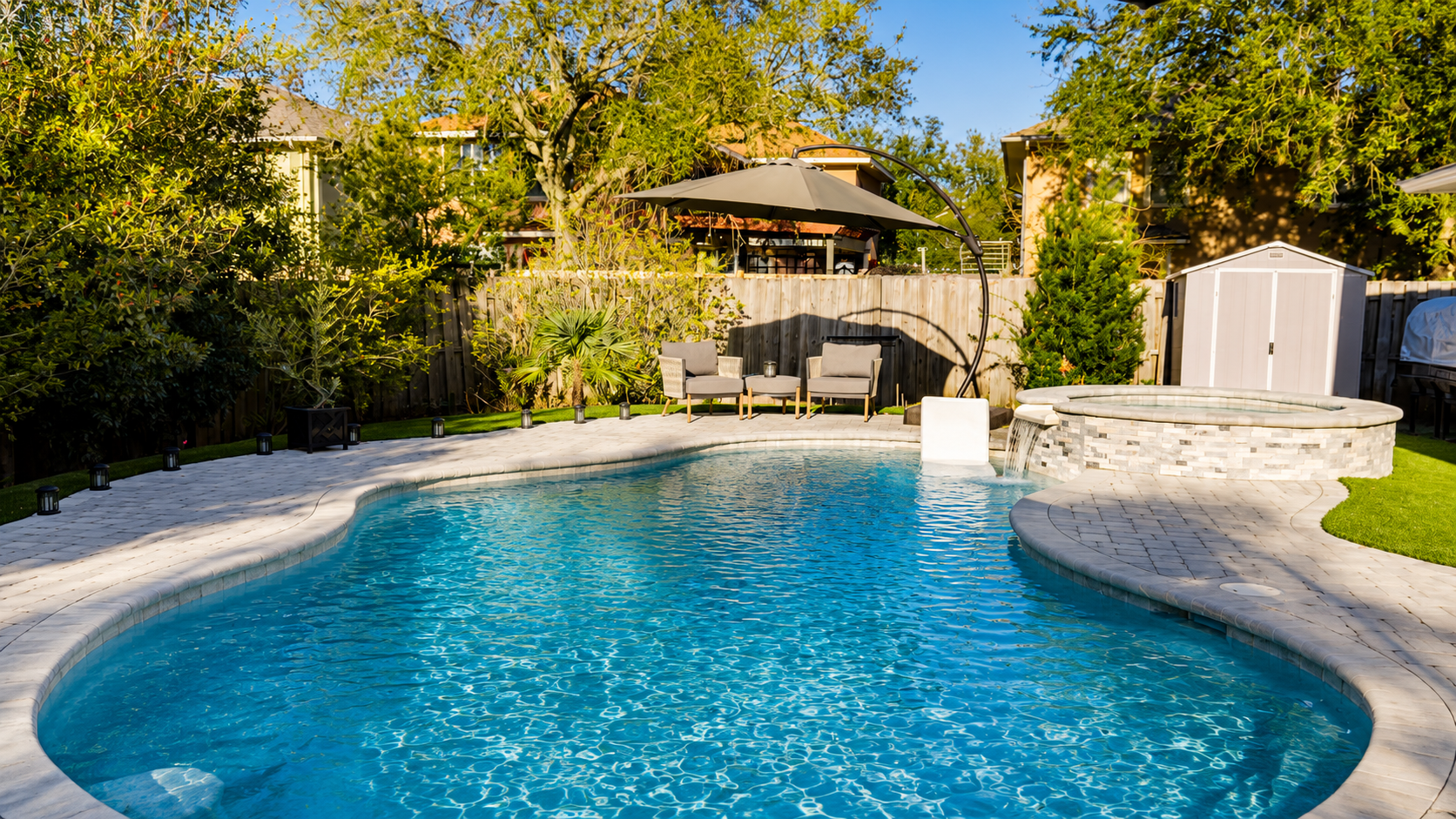 Freeform Neway pool with spa waterfall and paver patio