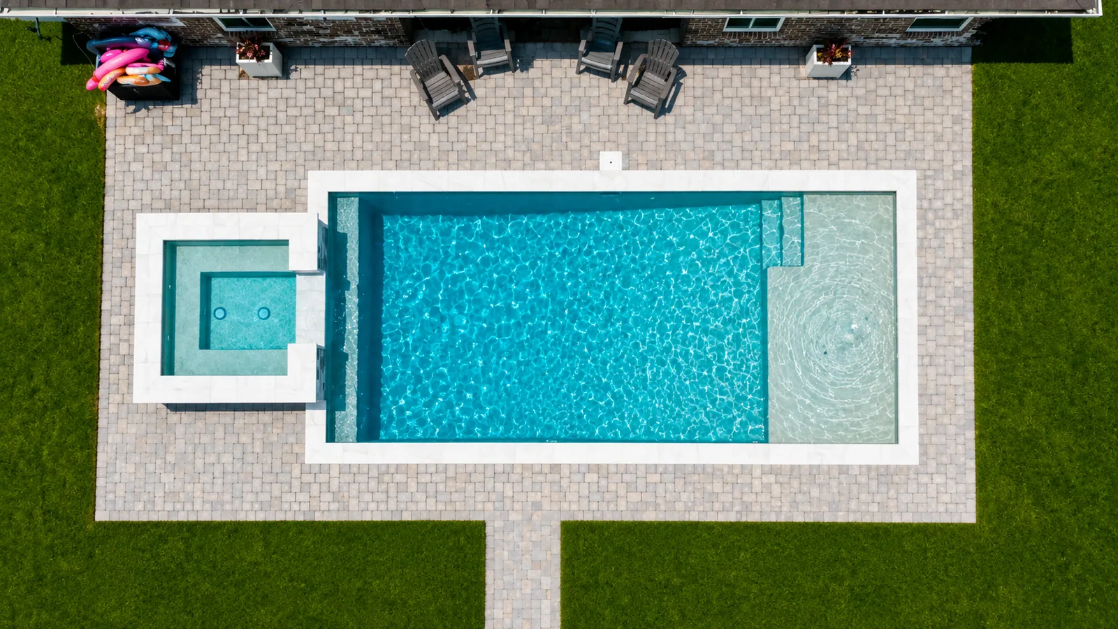 Custom pool with a tanning ledge and paver decking Custom pool with a tanning ledge and paver decking