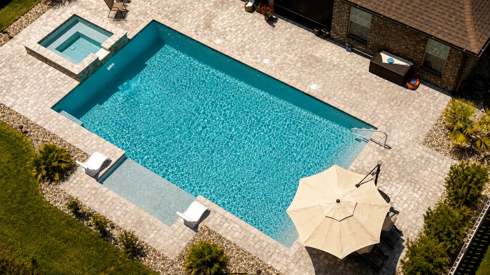 Newly built rectangular Neway pool with spa, tanning ledge and paver deck