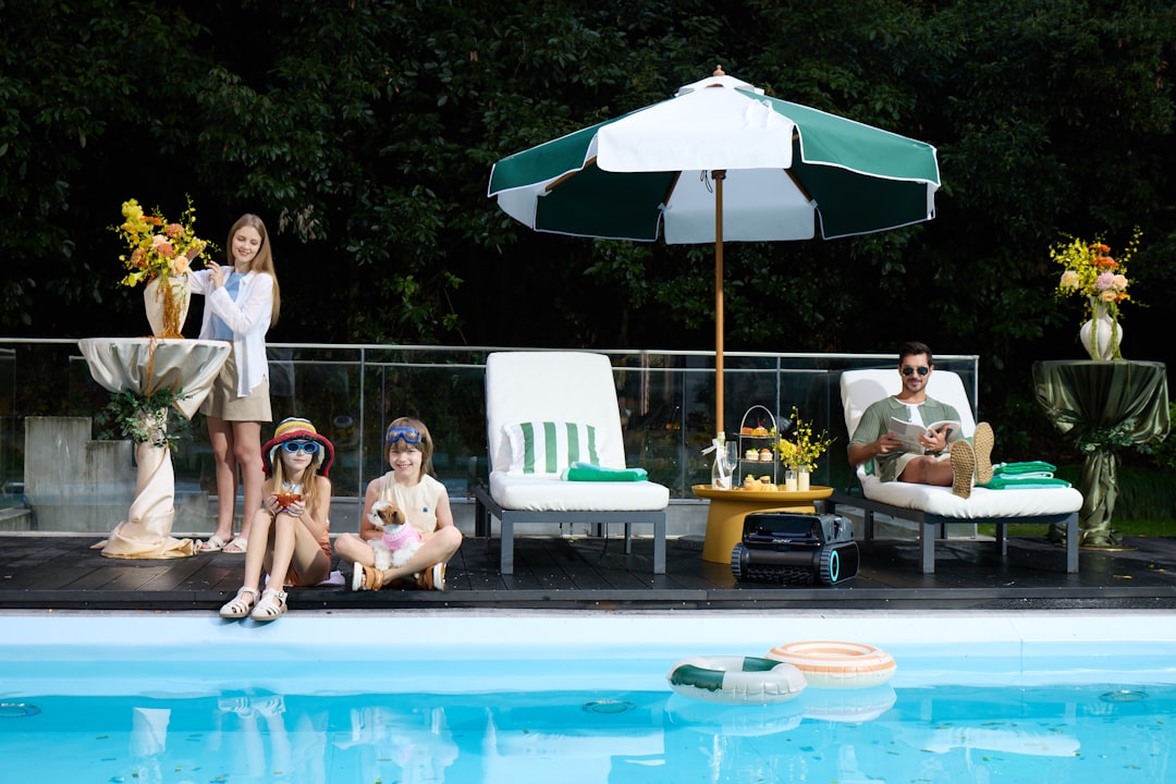 family enjoying a sunny day in their modern swimming pool - Pool Builders Cumming GA