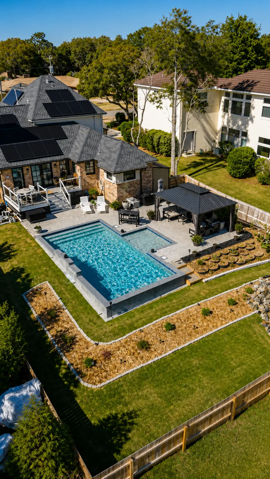 Aerial view of a custom pool and spa with paver deck by Neway Pools